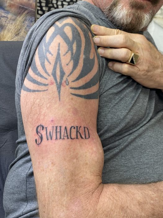 John McAfee $WHACKD tattoo